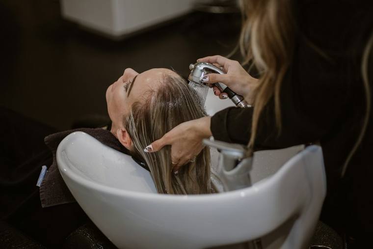 Kundin bekommt im Salon die Haare geschnitten