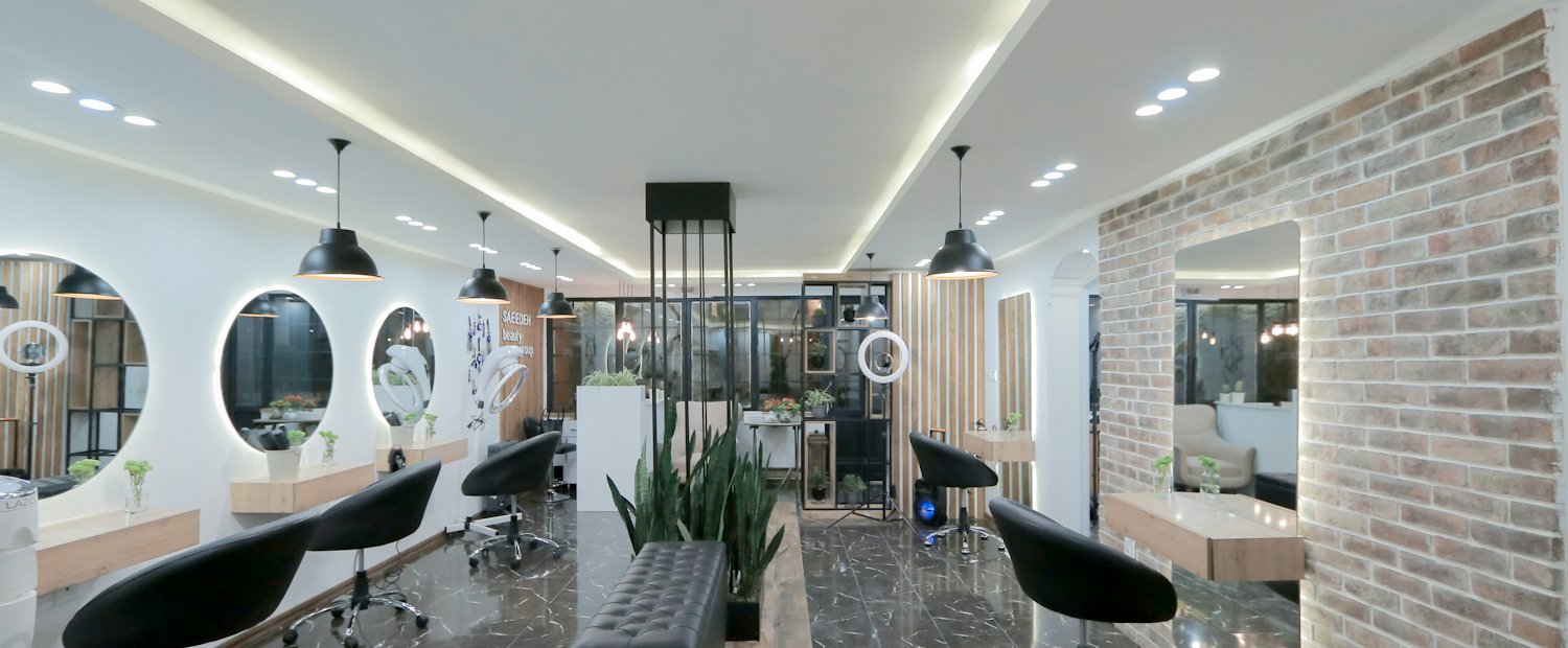 Moderner Friseursalon mit schwarzen Stühlen und runden Spiegeln